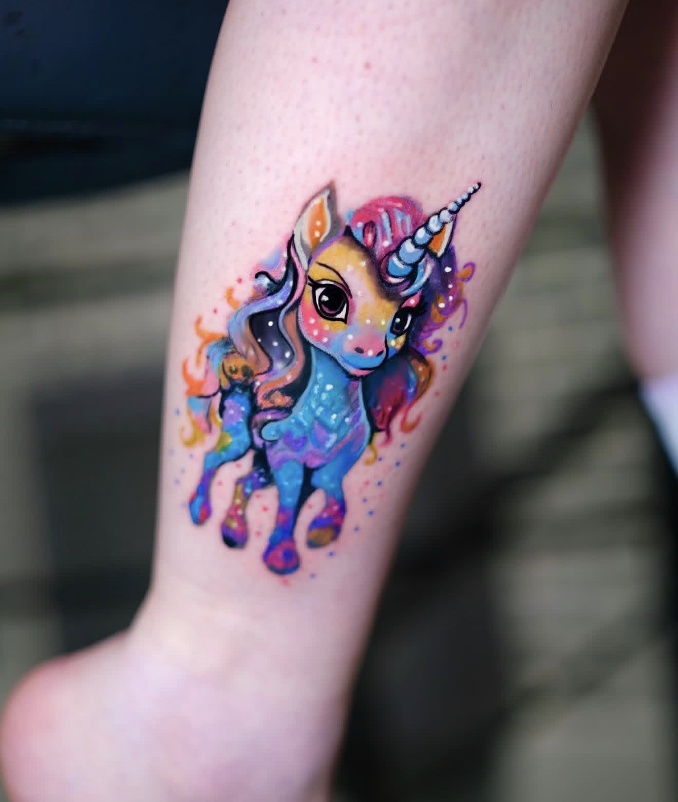 animation tattoo of a colorful unicorn character with vibrant colors, playful expression and cartoon style