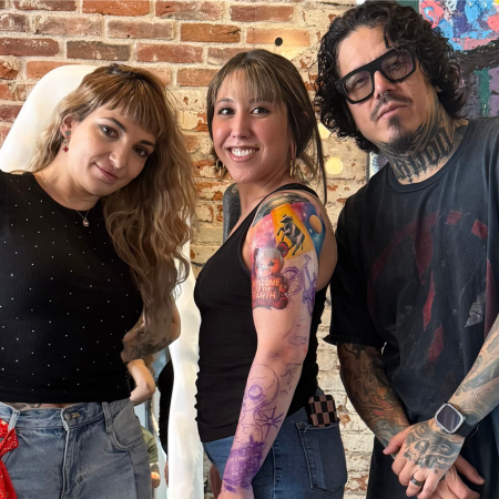 Happy client showing a colorful tattoo during a session at MT Tattoo Collective
