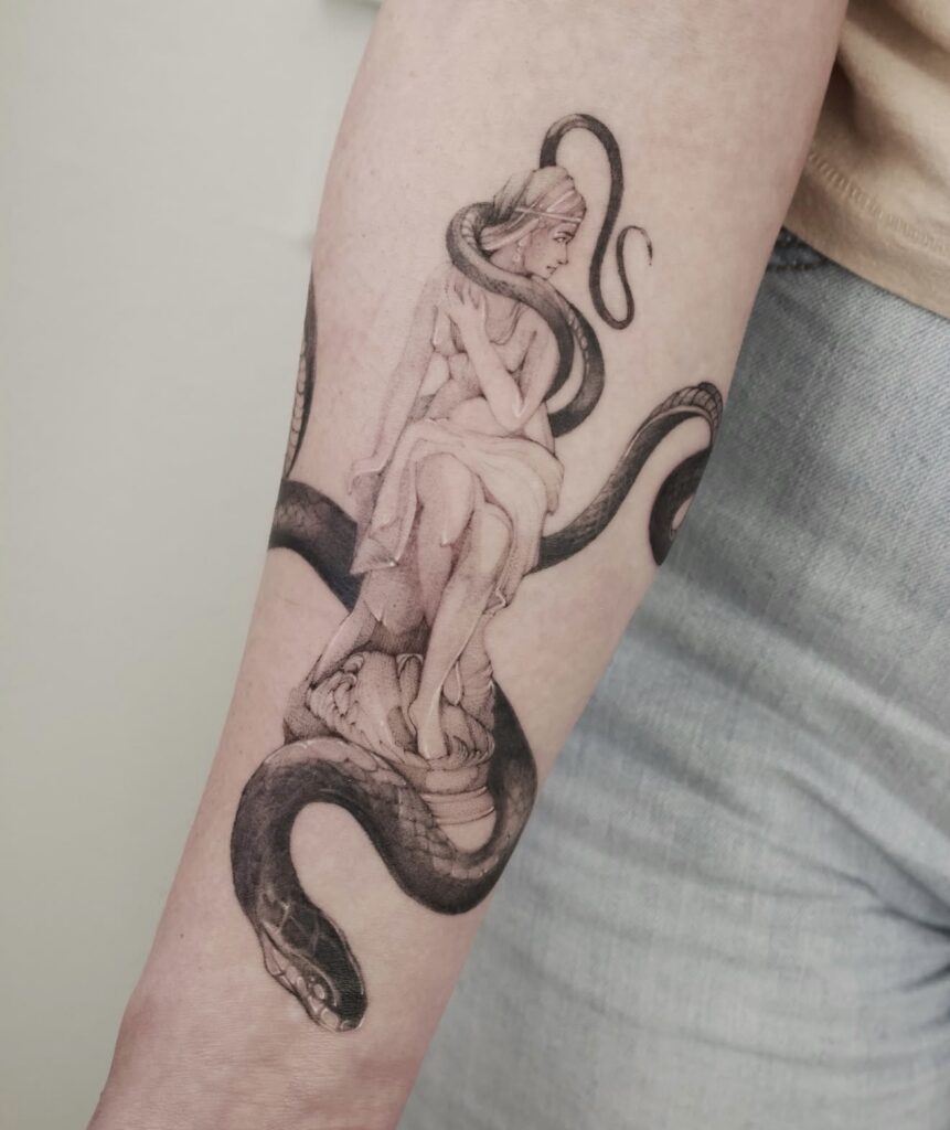 Fine line woman with serpent tattoo on forearm