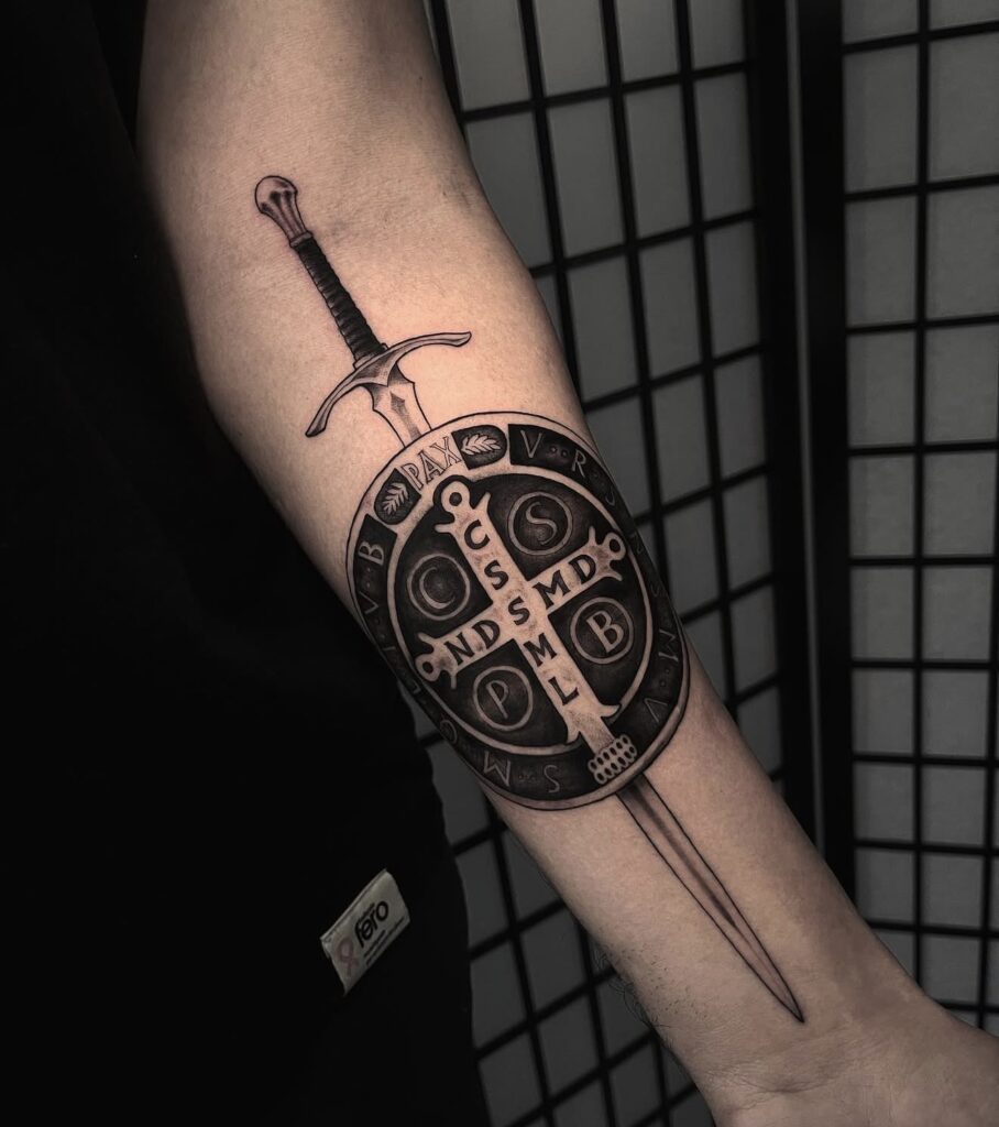 Fine line sword and shield medallion tattoo on forearm